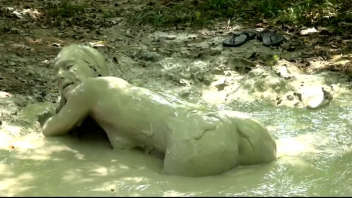 Découvrez une vidéo excitante où une femme séduisante s'aventure dans les bois pour prendre un bain de boue et se livrer à des plaisirs solitaires. Ne manquez pas cette scène torride.