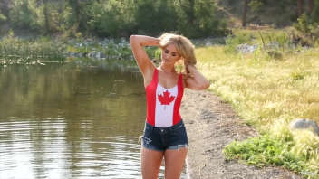 Explore the beauty of a Canadian lake with a charming young woman in a maple leaf swimsuit. A captivating sight for nature and swimsuit enthusiasts alike.