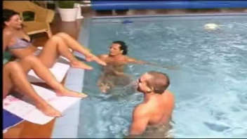 Quatre amis se rafraichissent dans la piscine et boivent des cocktails