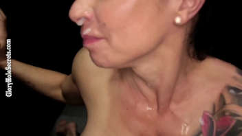 This mature, tattooed woman with a fit body is caught behind a wall, giving oral sex and draining the balls of the guys.