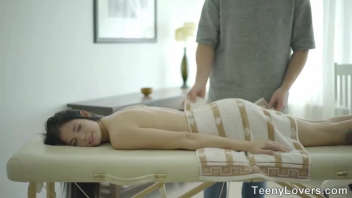 Lors d'un massage, cette jeune femme brune se détend et se sent plus à l'aise. Elle est susceptible de revenir plus souvent pour des séances de massage relaxantes.