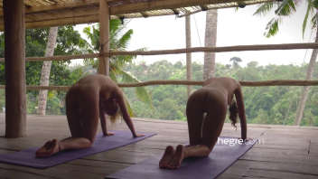 Two young naked women do yoga in Bali